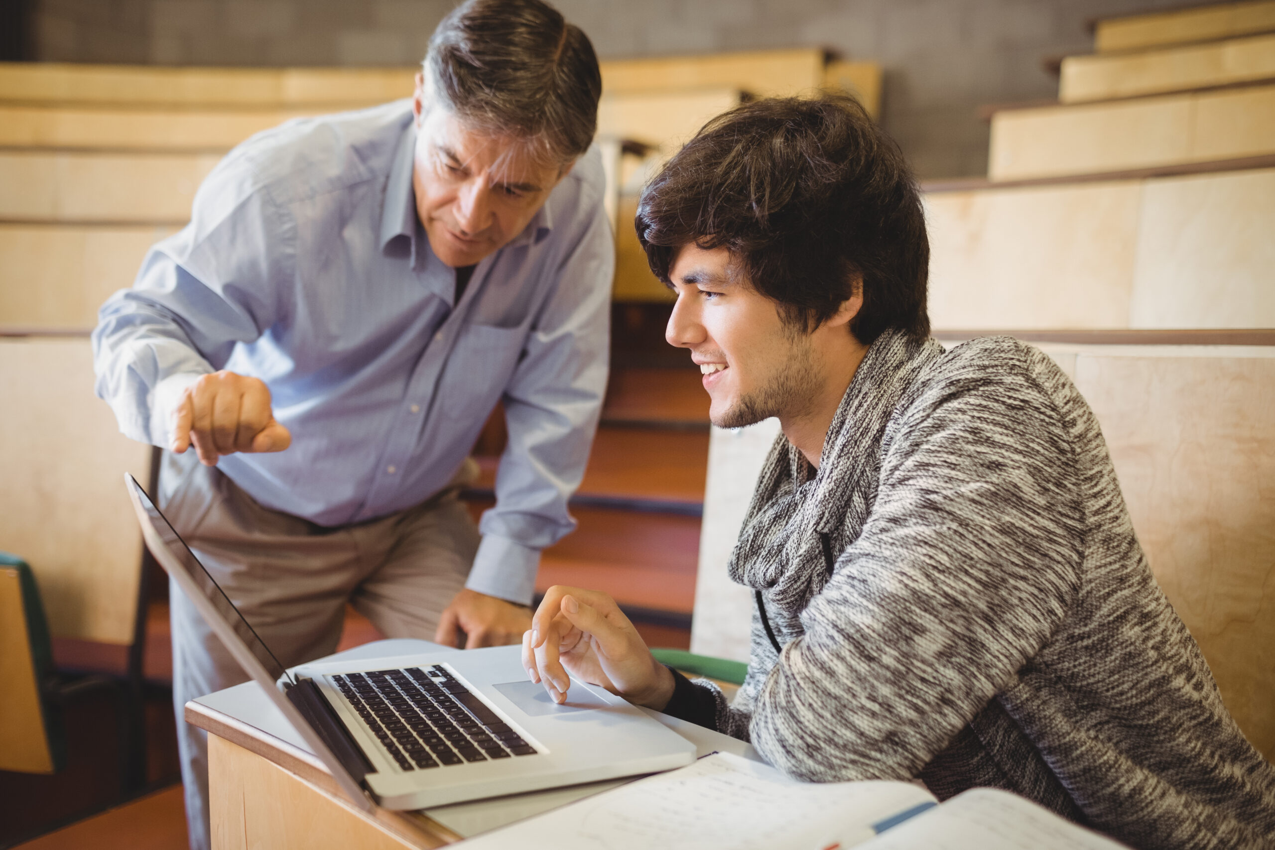 Professor helping a student in classroom at college