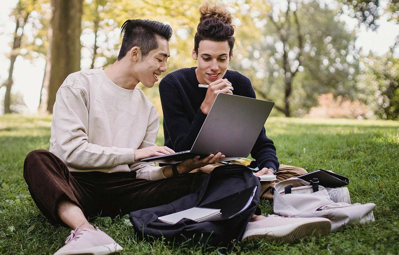 College Men Using Laptop in the Park